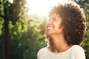 Close up side portrait of beautiful confident woman laughing in nature