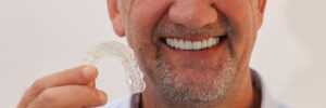 Mature Man holding clear aligners