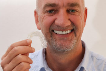 Mature Man holding clear aligners