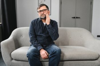 Man having toothache on sofa