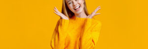 Young girl smiling on orange background