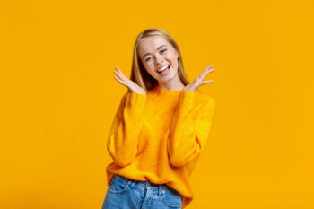 Young girl smiling on orange background