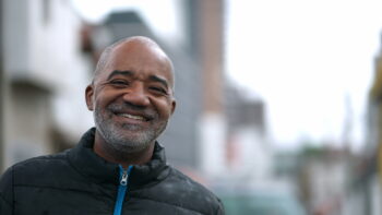 Smiling senior black man standing outside