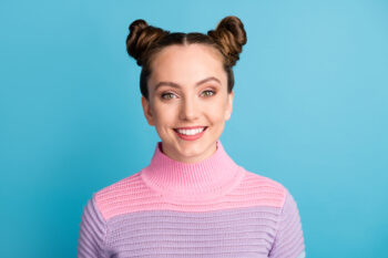 Woman wearing hair in buns on blue background