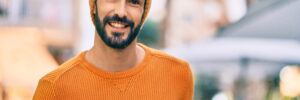 Young hispanic man wearing winter style smiling happy at the city.
