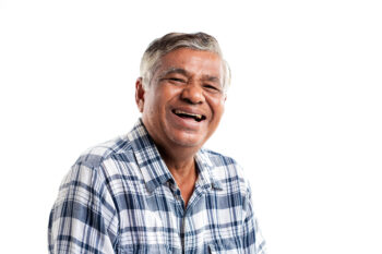 Portrait of an elderly man laughing happily isolated on white background.